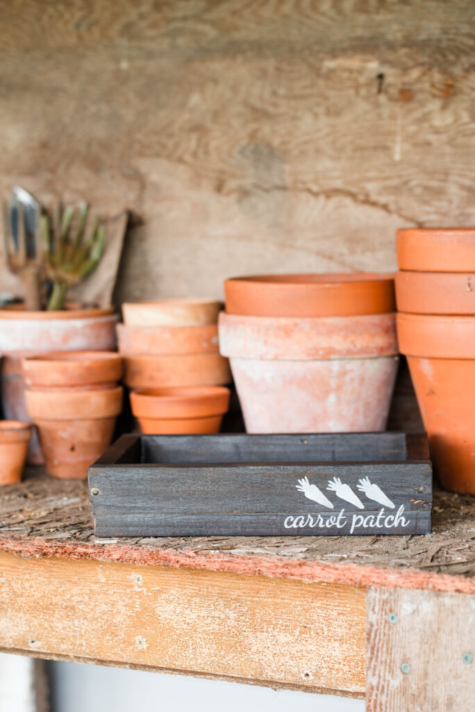 Wooden seed starting boxes sitting on a potting bench.