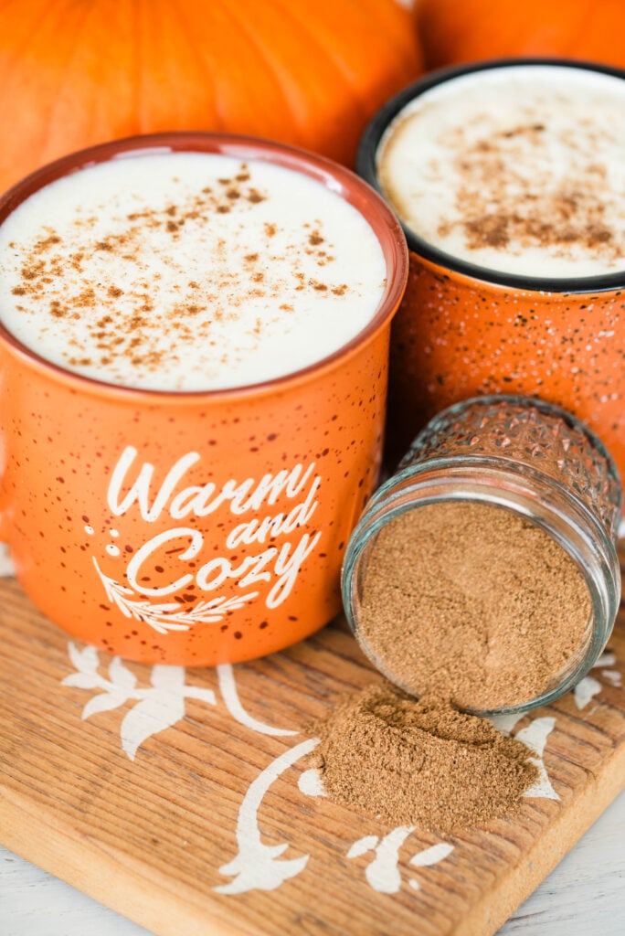 Two cups of pumpkin spice latte with a jar of homemade pumpkin spice mix.