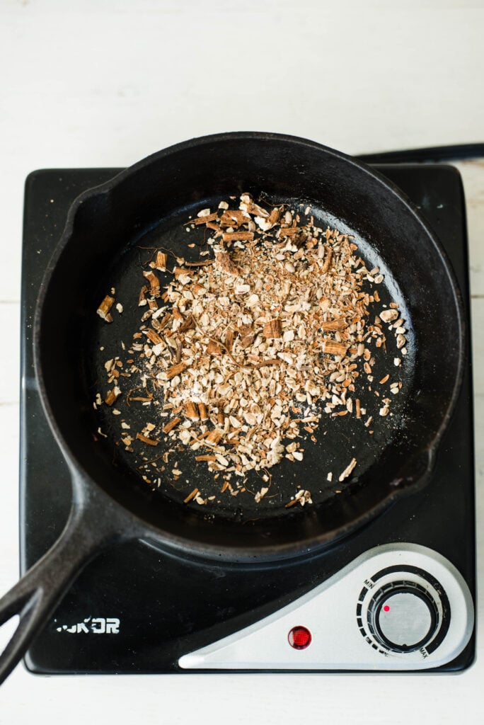 Dandelion root, milk thistle and burdock root roasting in a cast iron skillet.