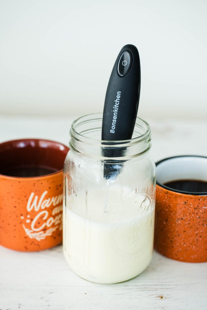 Milk frothed in a glass jar for a latte.